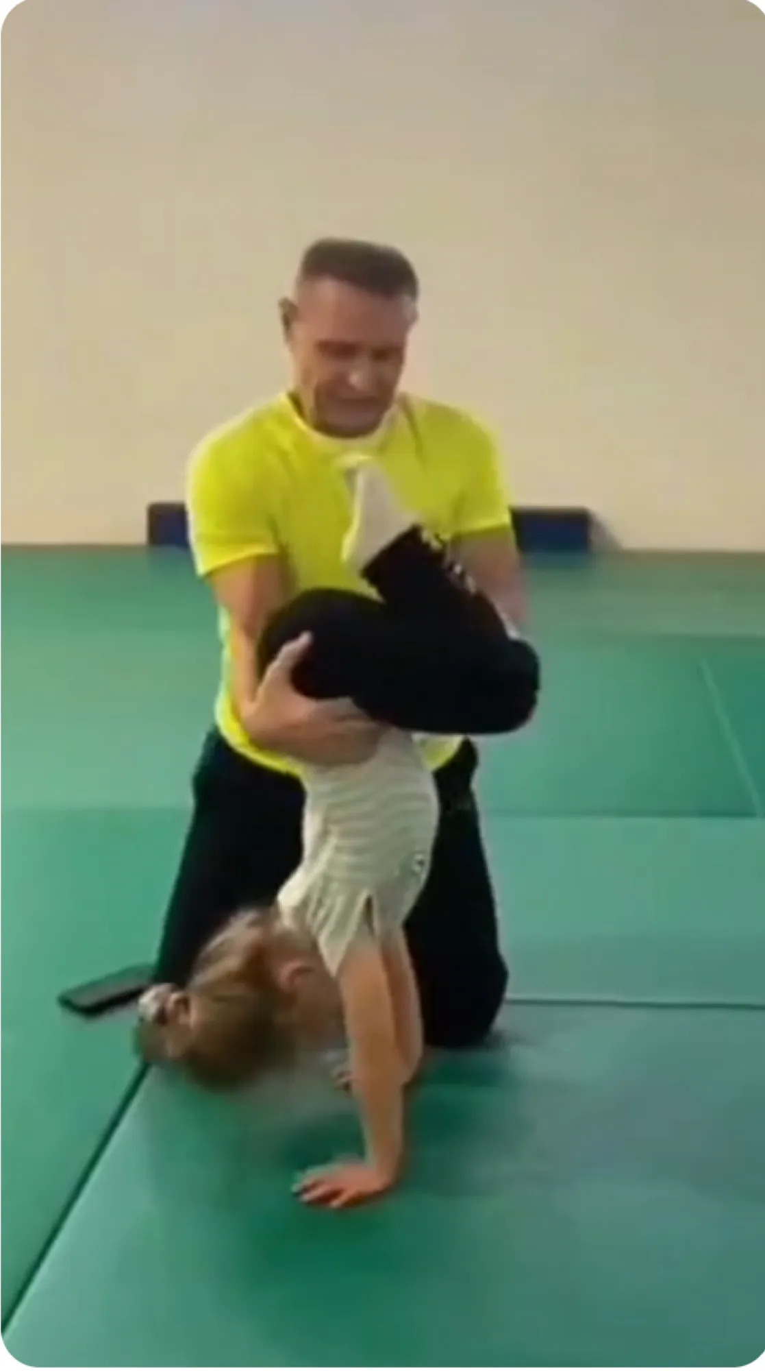 Trainer sichert ein Kind beim Akrobatiktraining